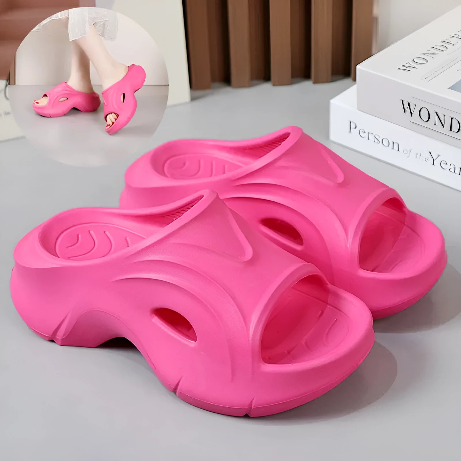 Women's thick-soled EVA slippers in rose red colour on a sandy beach background.