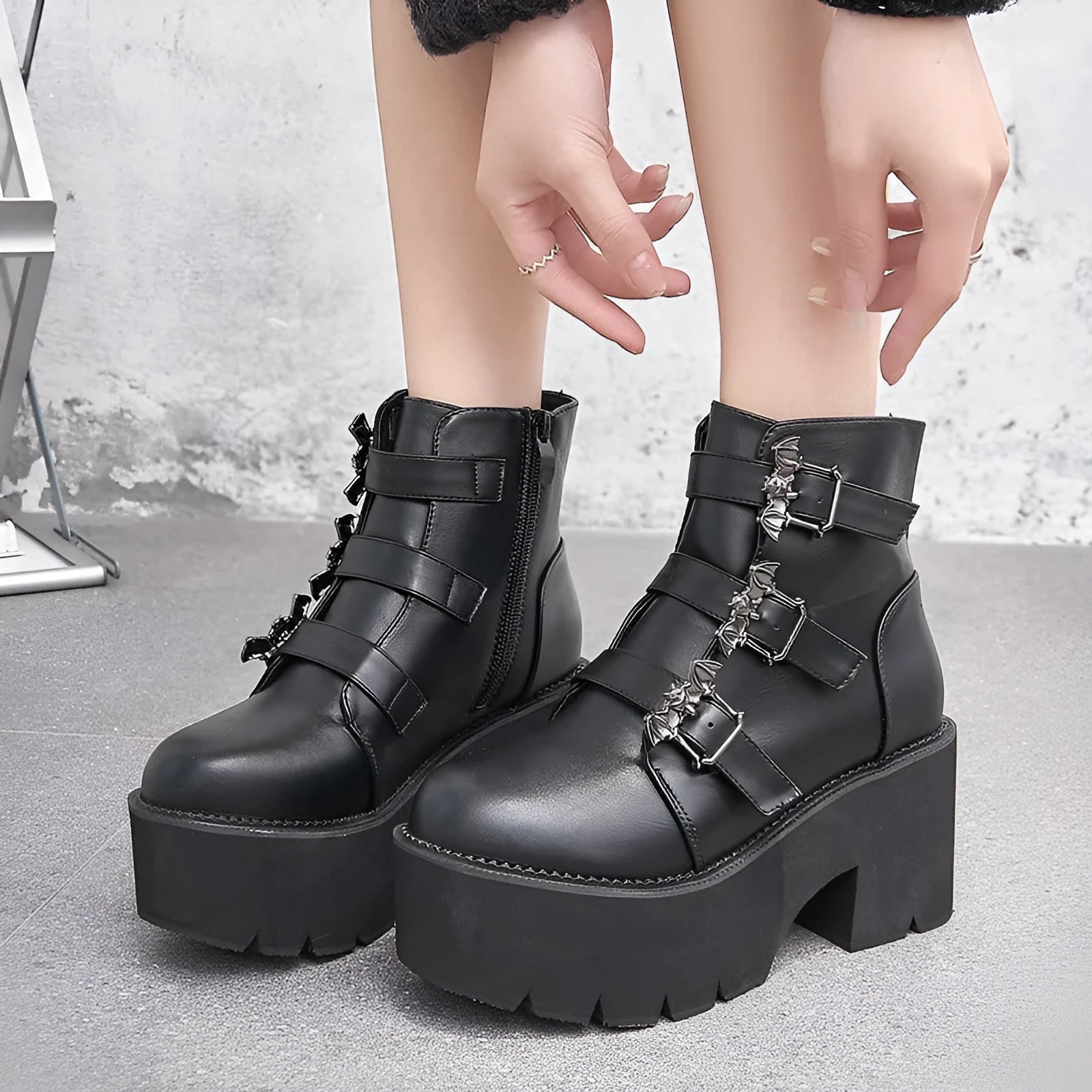 Black women's punk ankle boots with bat buckle, side zipper, thick heel, and round toe.