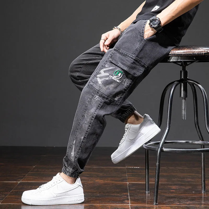 Men's loose fit blue cargo jeans with straight leg and cargo pockets on a plain background.