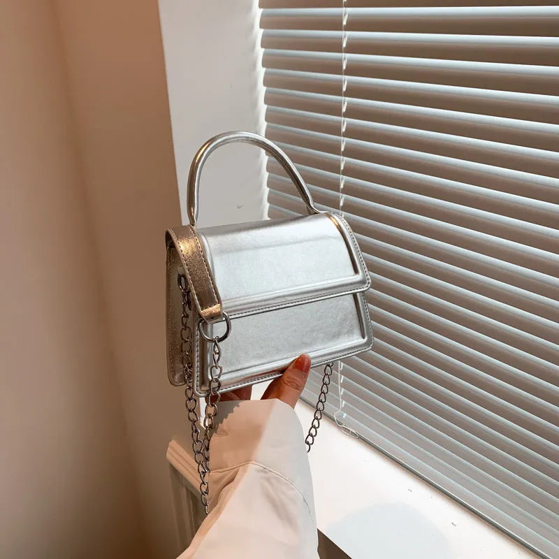 PU material crossbody shoulder bag in a horizontal square shape with visible sewing line details.
