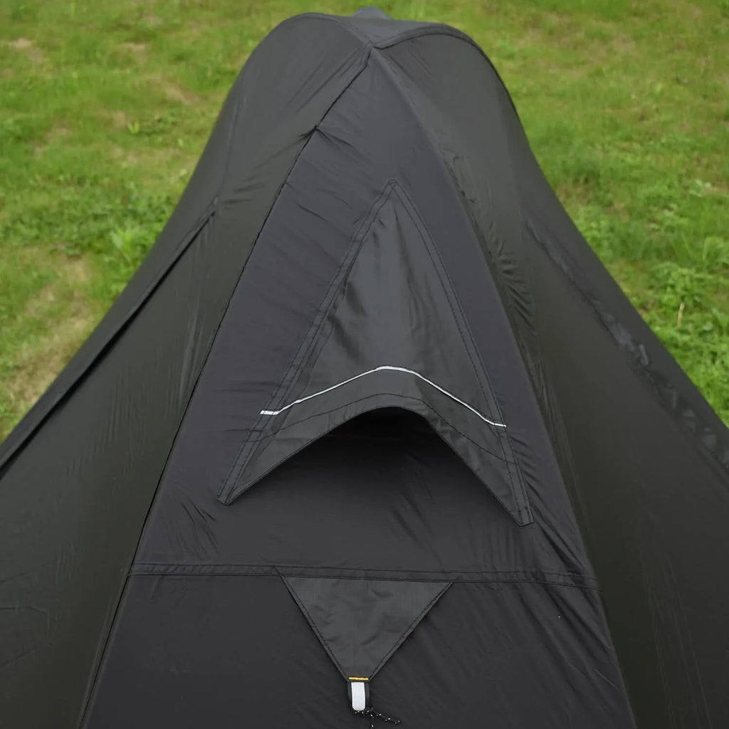 Red single person dome tent with aluminium poles pitched outdoors, showing double-layer construction.