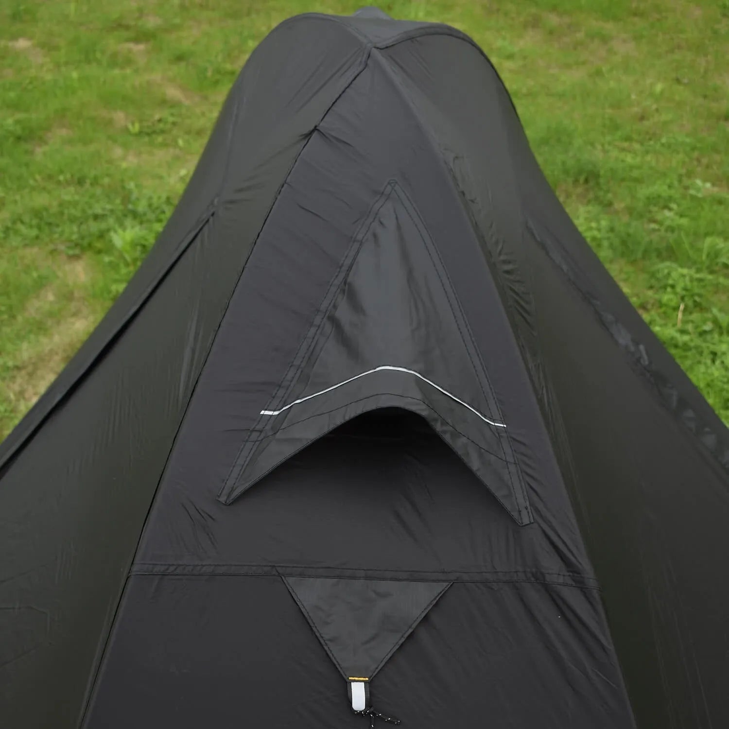 Red single person dome tent with aluminium poles pitched outdoors, showing double-layer construction.