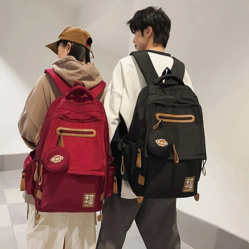 Large black nylon backpack for middle school students with curved shoulder straps and street style sewing details