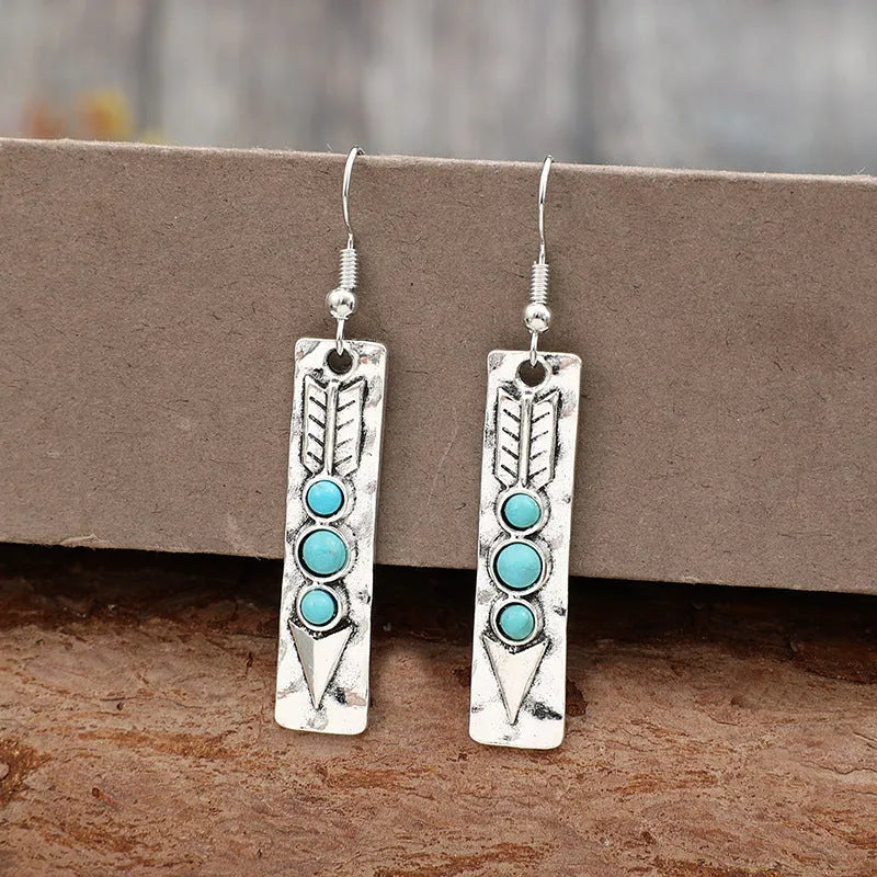 Silver geometric drop earrings with turquoise coloured inlays showing retro styling