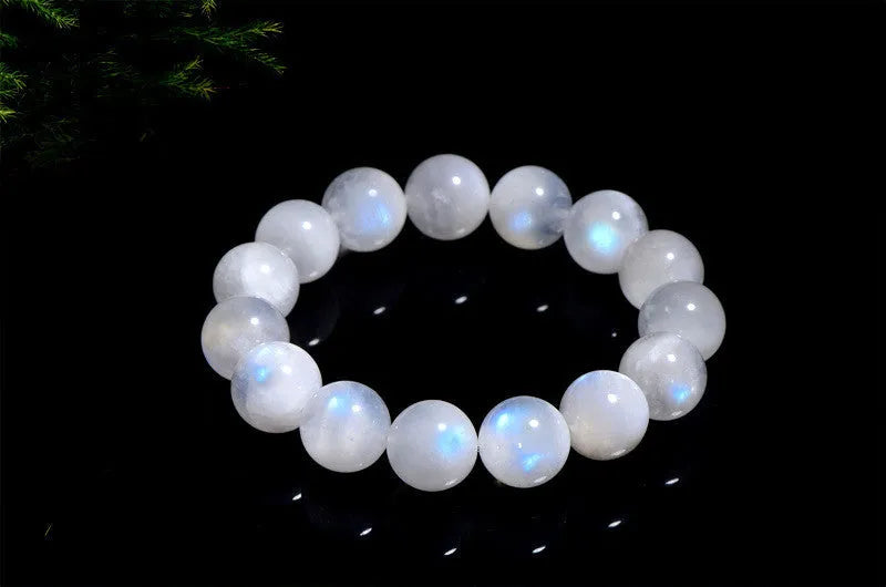 Natural blue moonlight round bead bracelet made from polished moonstone stones on a wrist.
