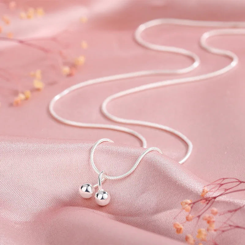 Silver cherry necklace for women with fruit pendant on a snake bone chain, adjustable length.