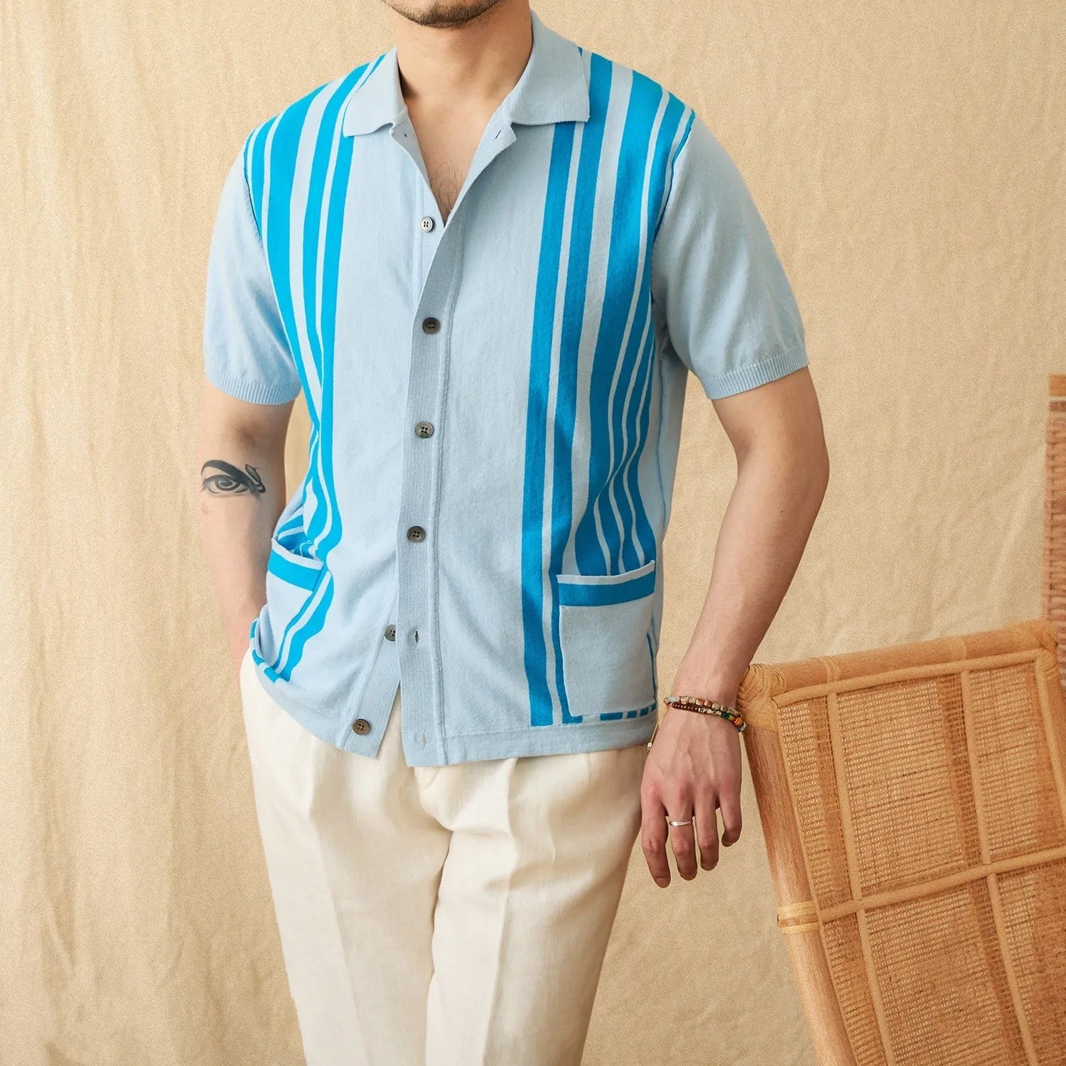Short-sleeved striped knit cardigan polo shirt with a lapel collar, shown in a light blue colour.