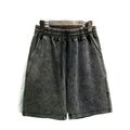 Men's distressed cotton shorts in straight-leg cut showing loose fit and solid colour options