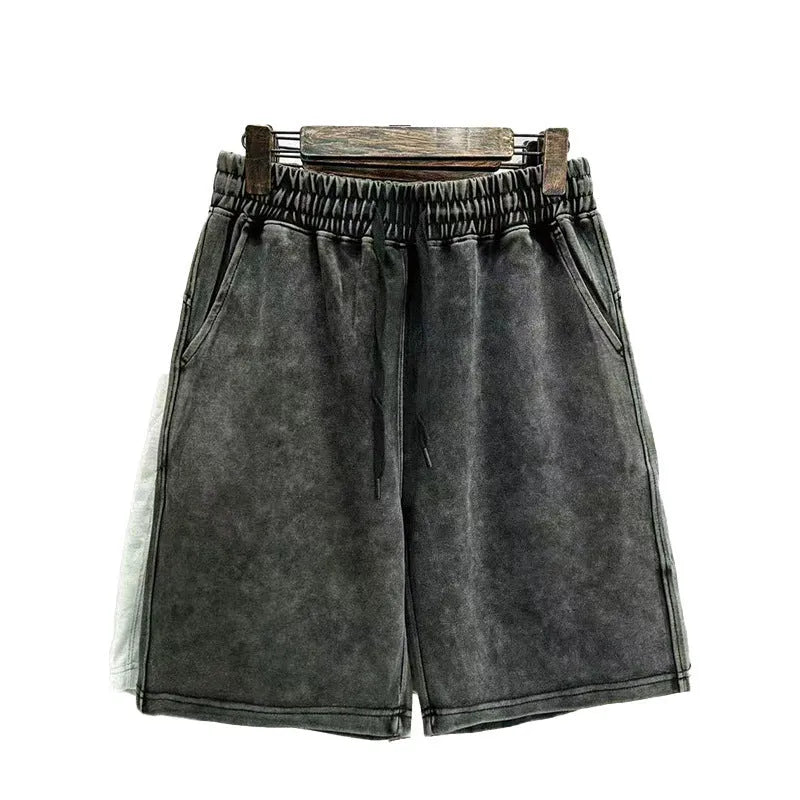 Men's distressed cotton shorts in straight-leg cut showing loose fit and solid colour options