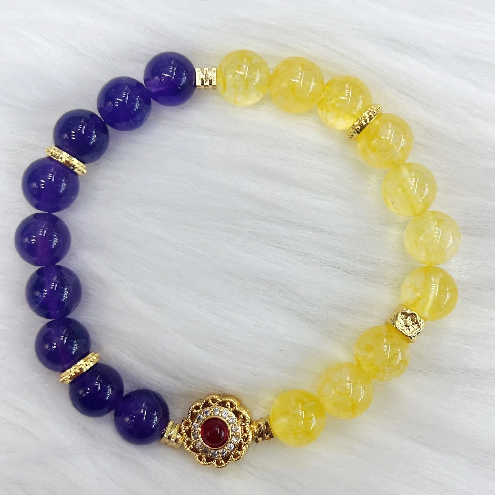 Handmade yellow and purple crystal women's bracelet on wrist.