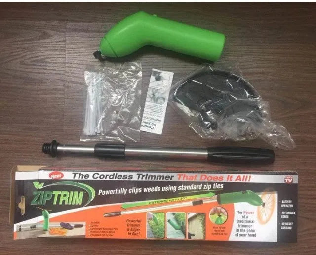 Cordless lawn trimmer with extension pole and protective shield on grass