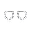 Pair of sterling silver geometric hoop earrings with round retro design elements