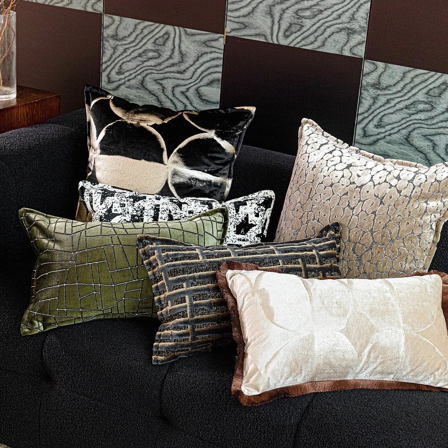 Abstract pattern black and gold decorative cushion pillow with removable cover on a grey sofa.