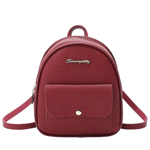 Small black women's PU backpack purse with a zipper, shown with a mobile phone for scale.