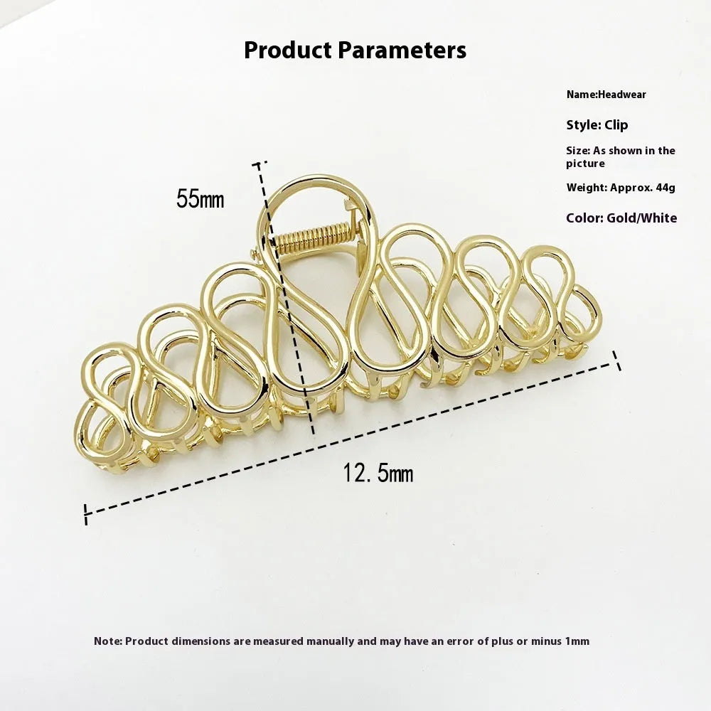 Large minimalist hair clip with tassel decoration in gold finish showing irregular shape design