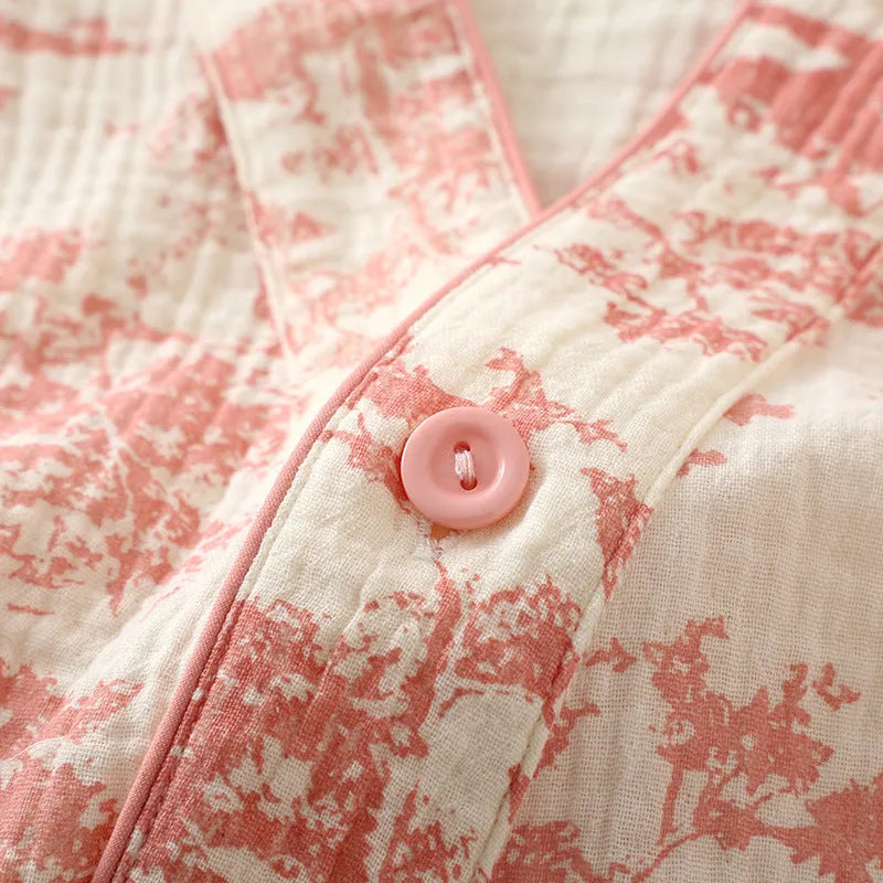 Women's pink cotton gauze long sleeve top and trousers lounge suit set on a hanger.