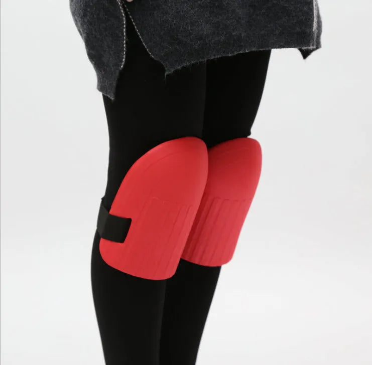 A pair of black EVA foam knee pads for gardening, shown from above on a hard surface.
