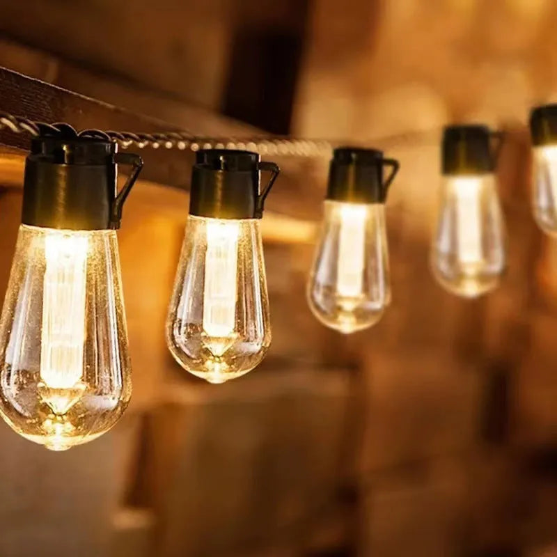 Retro infusion bottle shaped glass bulb outdoor string lights in garden setting