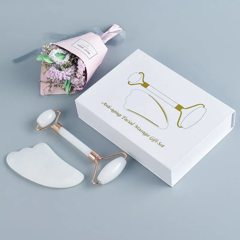 White jade facial roller and matching massage board set on a flat surface.