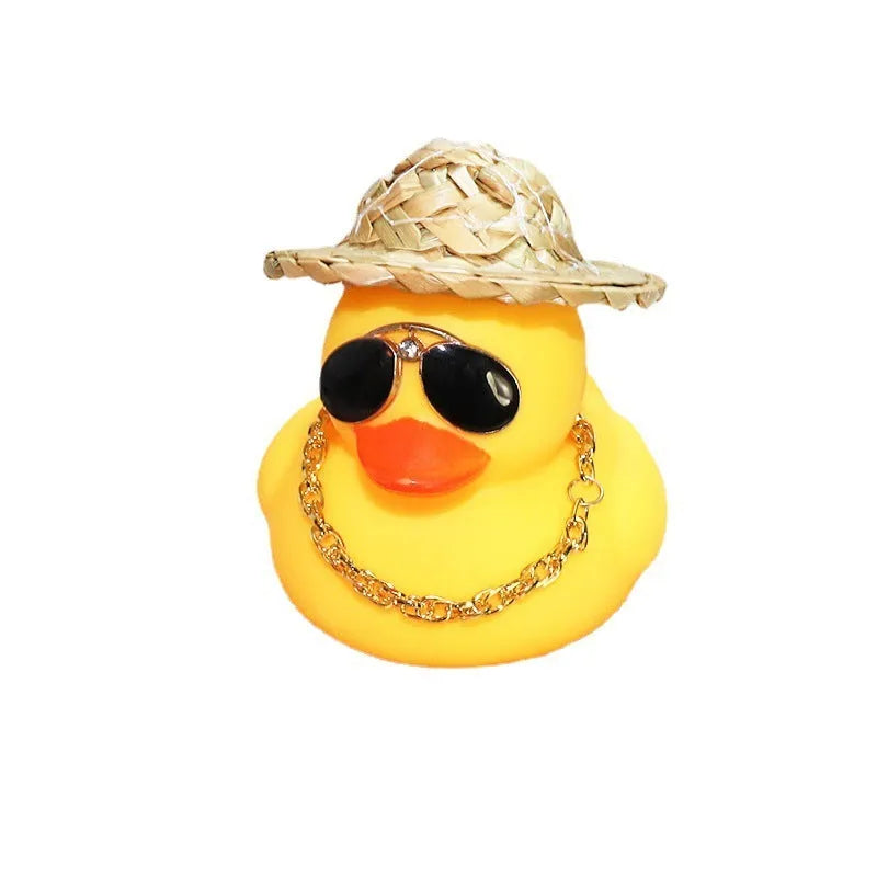 Cartoon yellow duck wearing a straw hat car dashboard ornament on a matte yellow base.