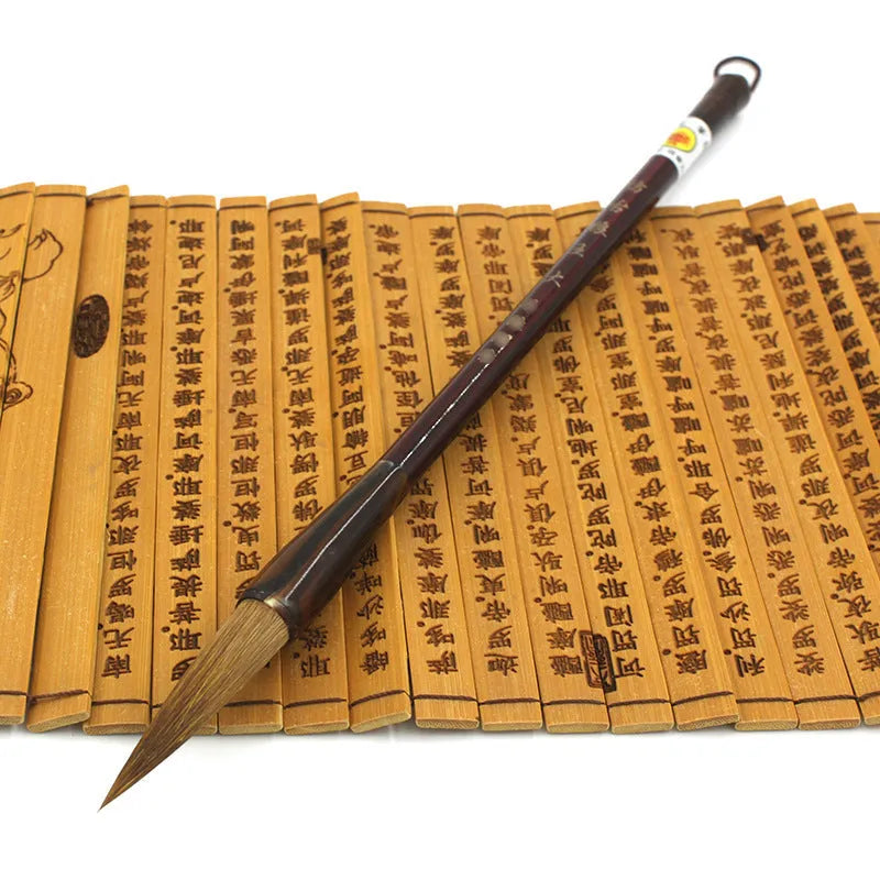 Set of three traditional Chinese calligraphy brushes with wolf hair bristles and steel ferrules in large, medium, and small sizes.