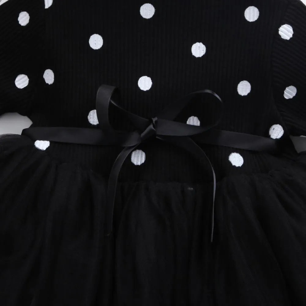Baby girl wearing a long sleeve black tutu dress with lace detail, suitable for a party or casual wear.