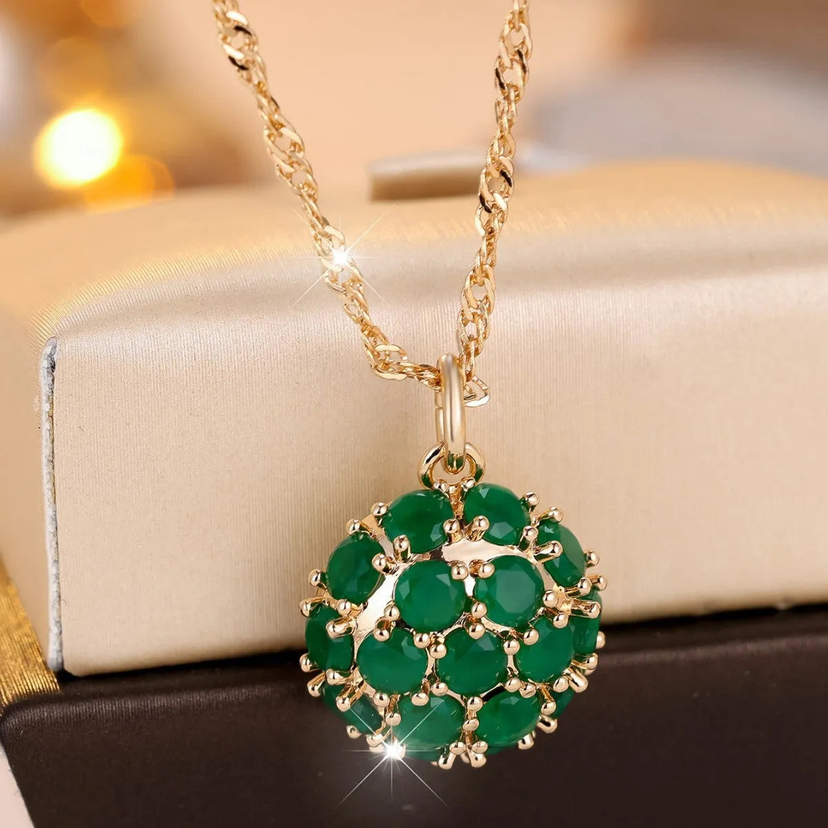 Round emerald and diamond pendant on an adjustable champagne gold electroplated copper chain necklace.