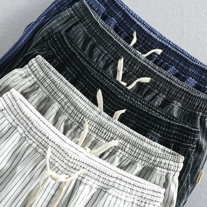 Man wearing black and white striped casual cotton shorts with a loose straight leg fit.