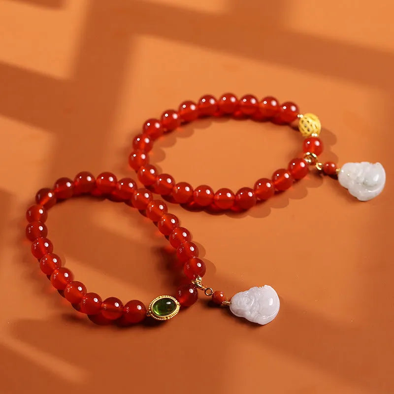 Handmade red agate and amber bracelet with geometric beads and a gold Maitreya Buddha charm.