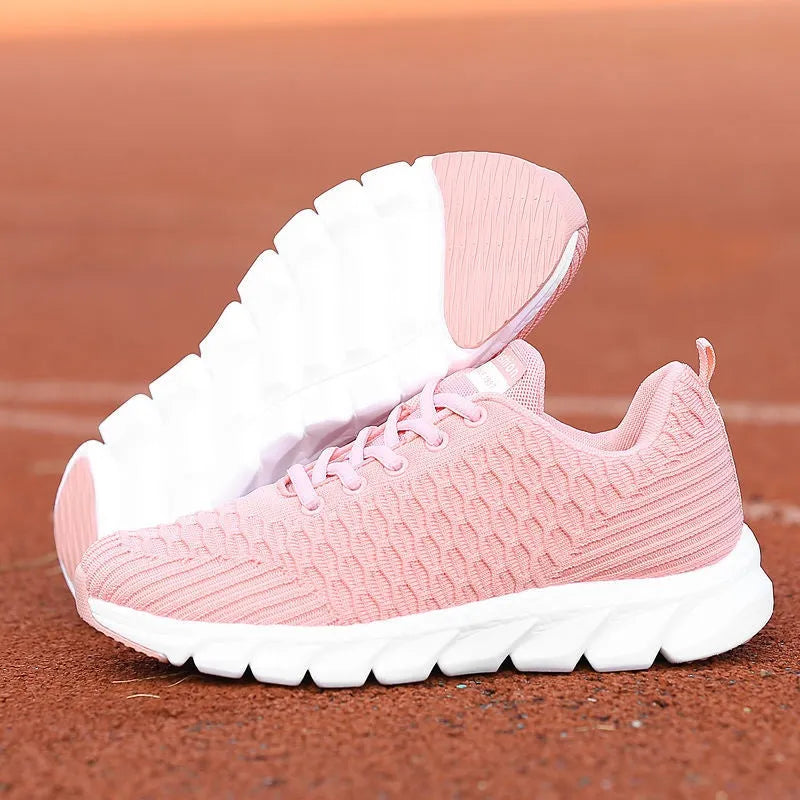 Women's running shoes in black, pink, or white with a breathable fly knit upper and durable outsole.