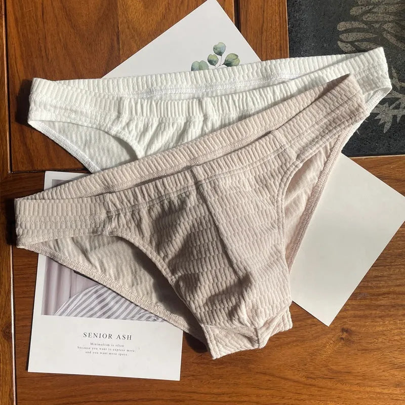 Men's solid colour cotton triangle briefs on a mid-waist, showing apricot, black, white and skin colour options.
