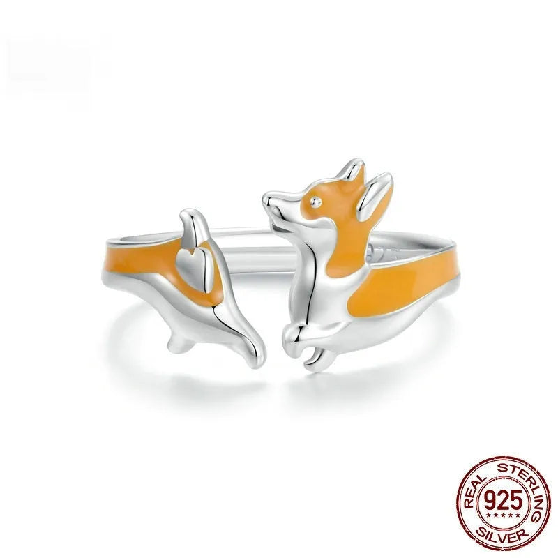 Close-up of a silver-coloured adjustable ring with a detailed cartoon corgi dog design on its face.