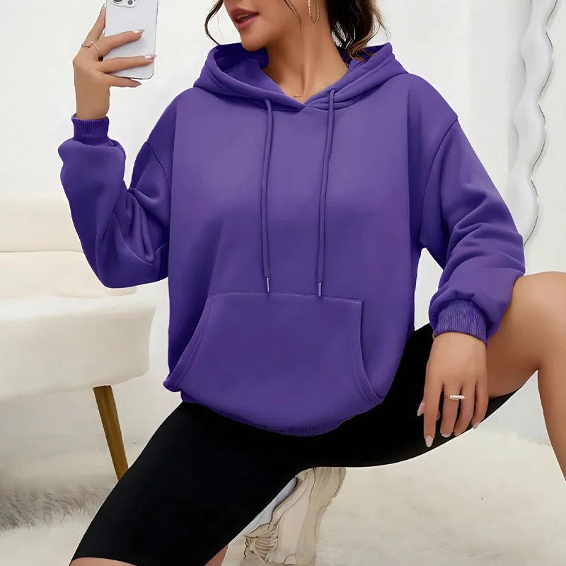 Loose grey women's sweatshirt with a drawstring waist and long sleeves on a hanger.