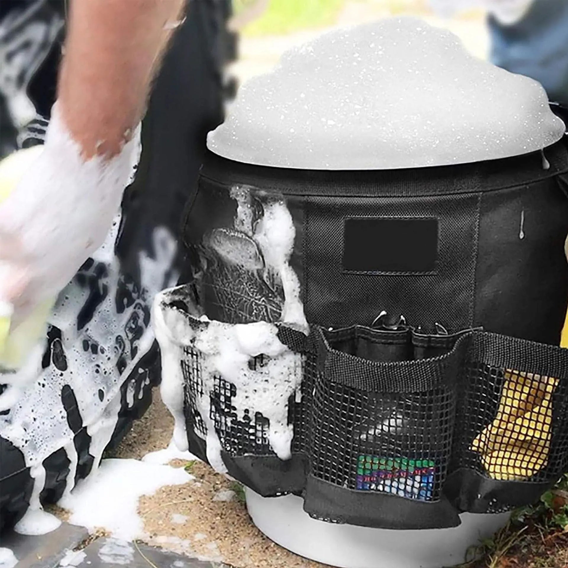 Black cylindrical polyester storage bag hanging from the rim of a 5-gallon barrel.