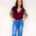 Burgundy women's loose sweater with contrast trim, V-neck, and cuffed short sleeves