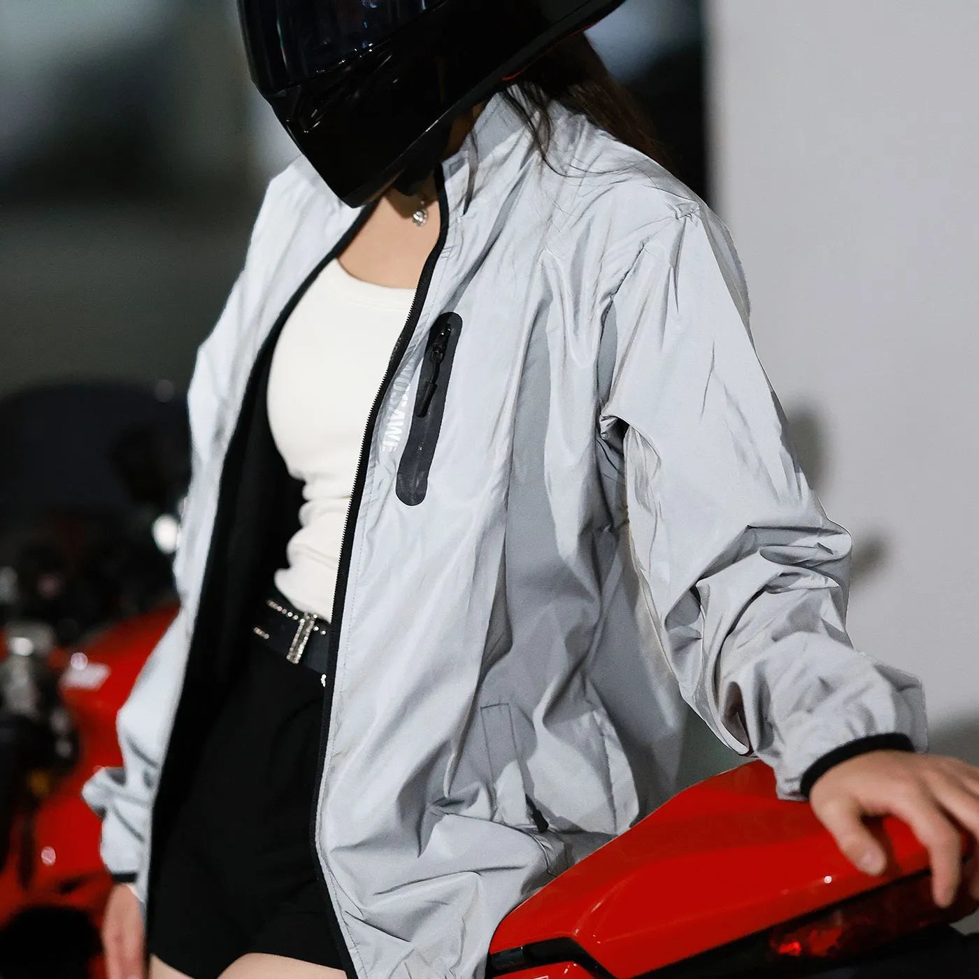 Silver waterproof polyester long sleeved coat on a hanger, showing front design.
