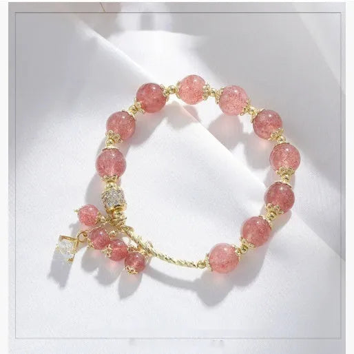 Pink women's bracelet with heart-shaped strawberry quartz crystals and pearl bead accents on adjustable band