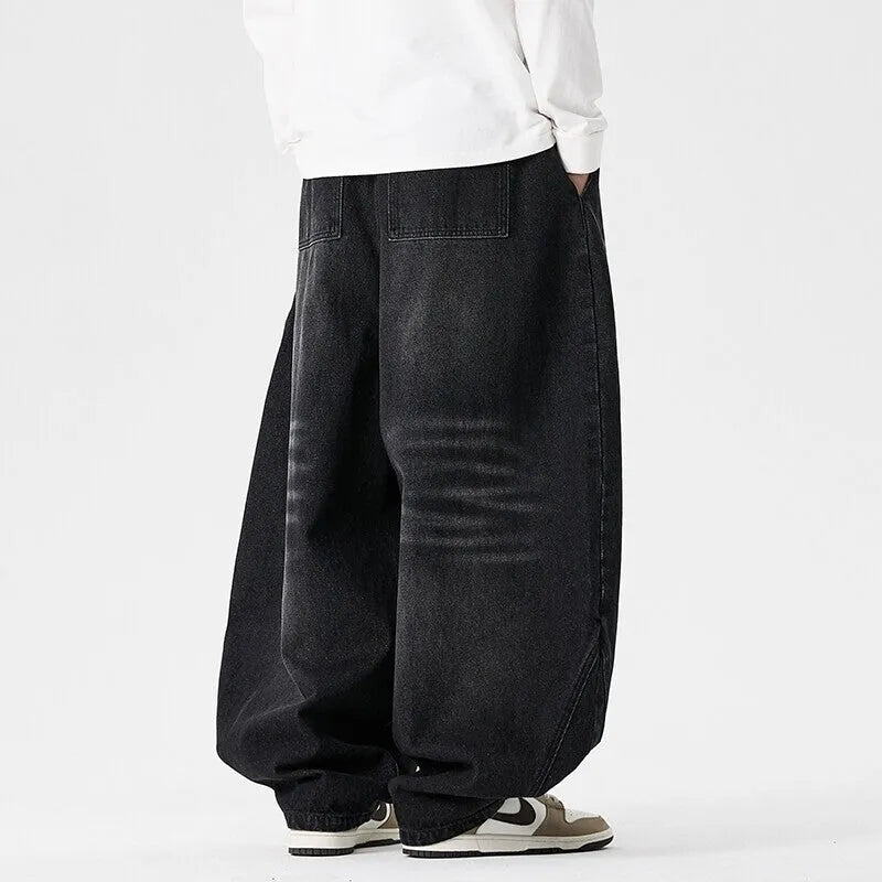 Men's plus size baggy blue jeans with wide straight legs on a hanger.