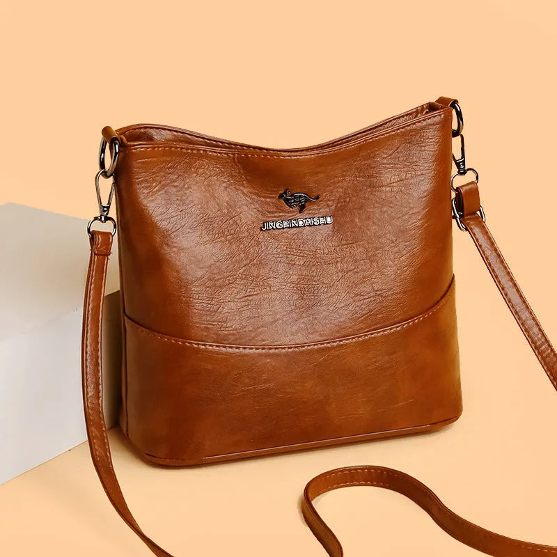 Women's soft leather shoulder bag in bucket design with minimalist luxury styling and mobile phone pocket