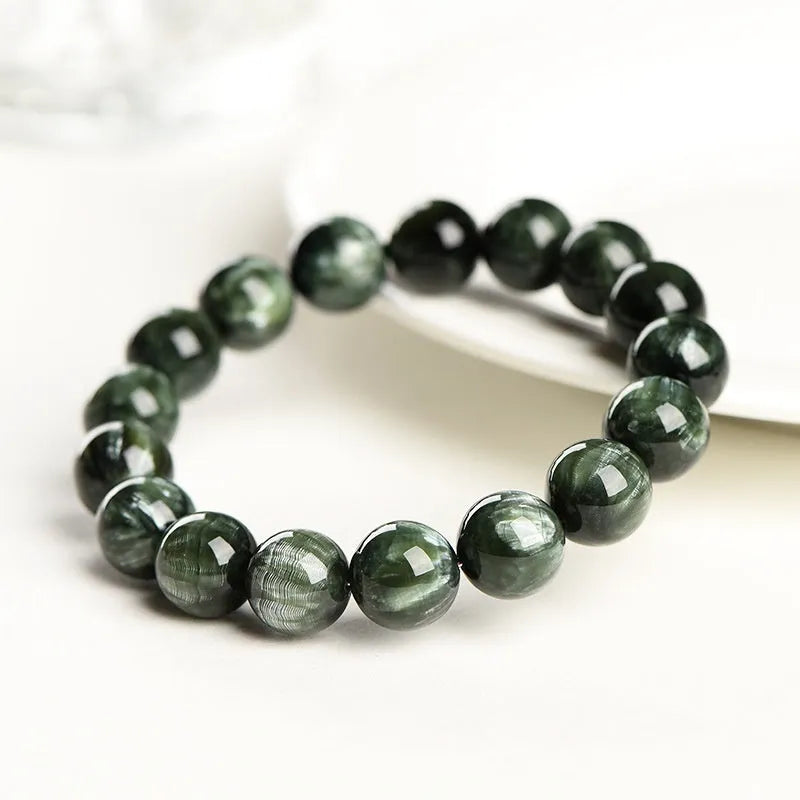 Natural green dragon crystal bracelet with 8-9mm round beads and Ruyi design on wrist.