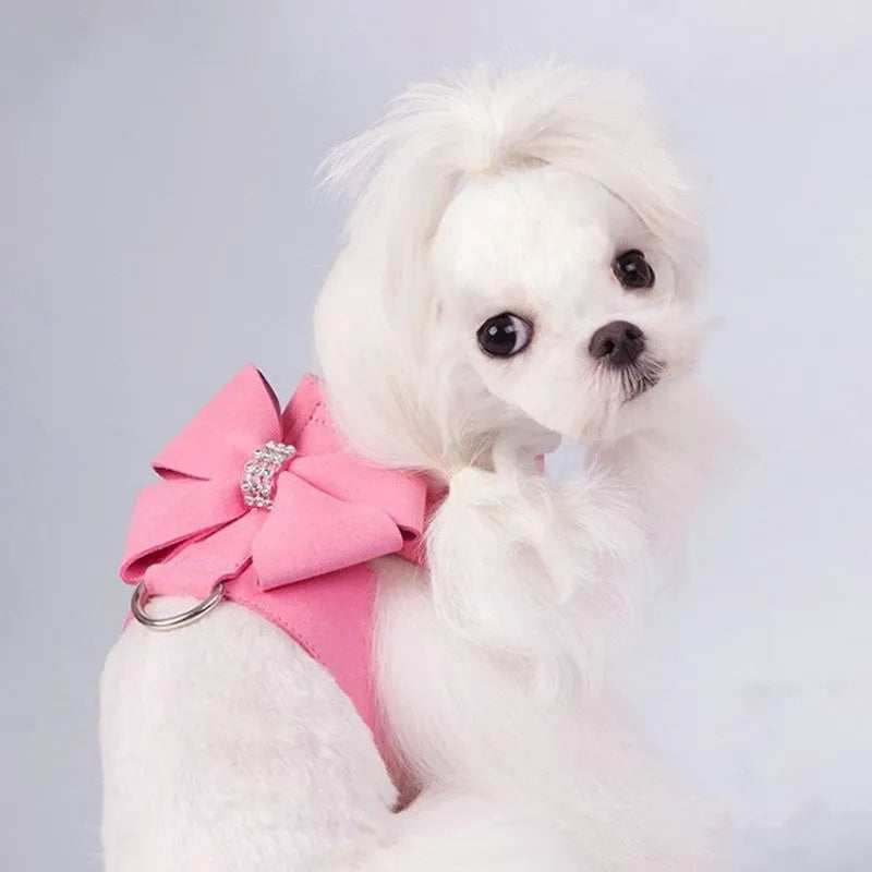 A pink microfiber puppy chest strap harness with a large bowknot, shown on a small dog.