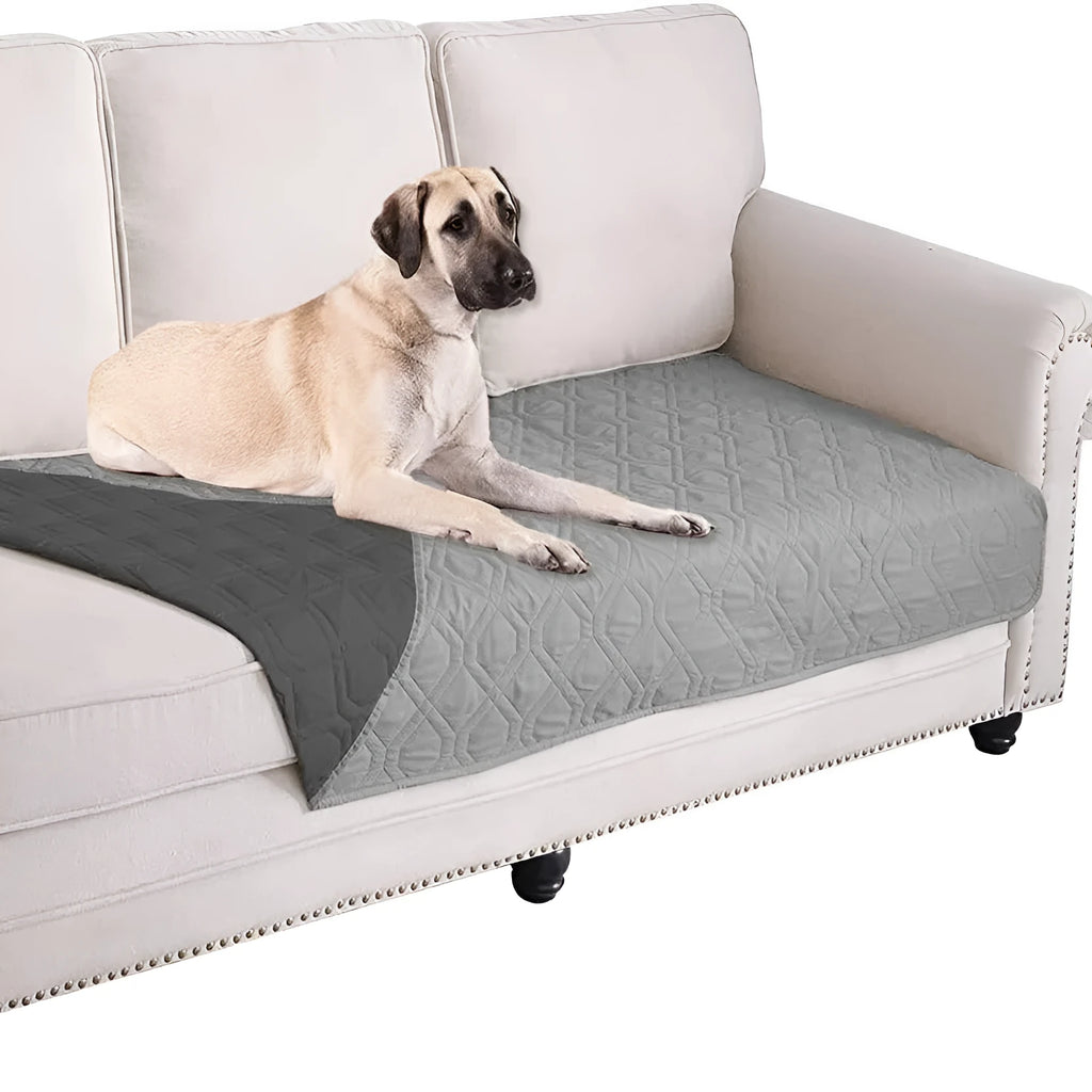 Reversible dog blanket on a sofa showing two colour sides, available in multiple sizes.