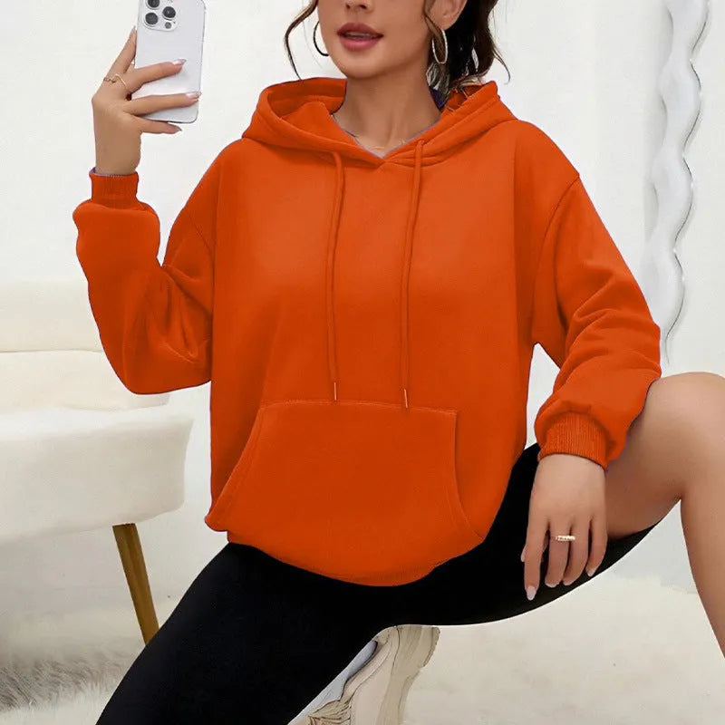 Loose grey women's sweatshirt with a drawstring waist and long sleeves on a hanger.