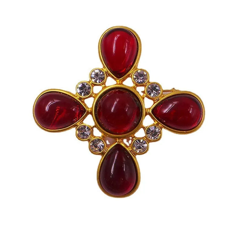 Close-up of a zinc alloy baroque brooch with a central crystal cross in a vintage style.