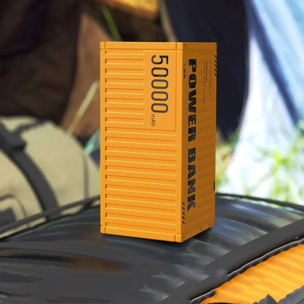 Large yellow 50000mAh power bank with digital display showing battery percentage and multiple USB ports.