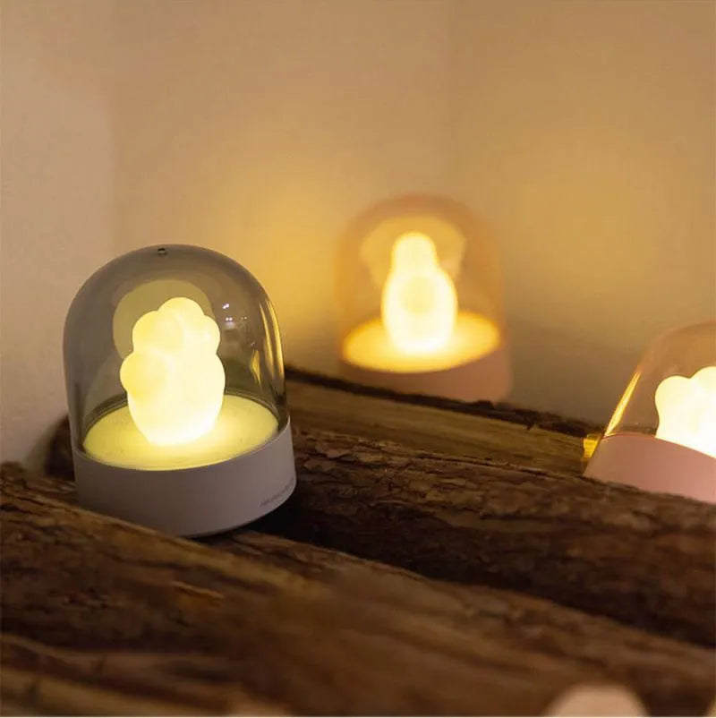 Pink cat paw shaped USB rechargeable night light with musical box function on wooden desktop
