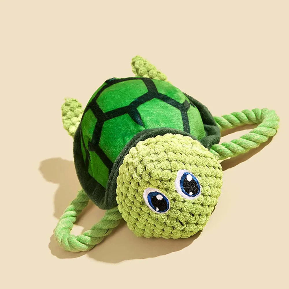 Green turtle shaped dog chewing toy with three rope knots extending from plush shell