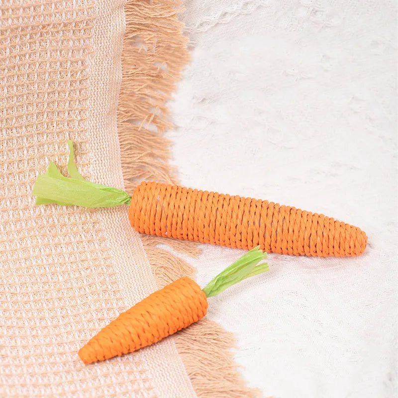 Set of cat toys including carrot shapes, crinkly paper balls, ringing stones, and dental grinding sticks in two sizes.