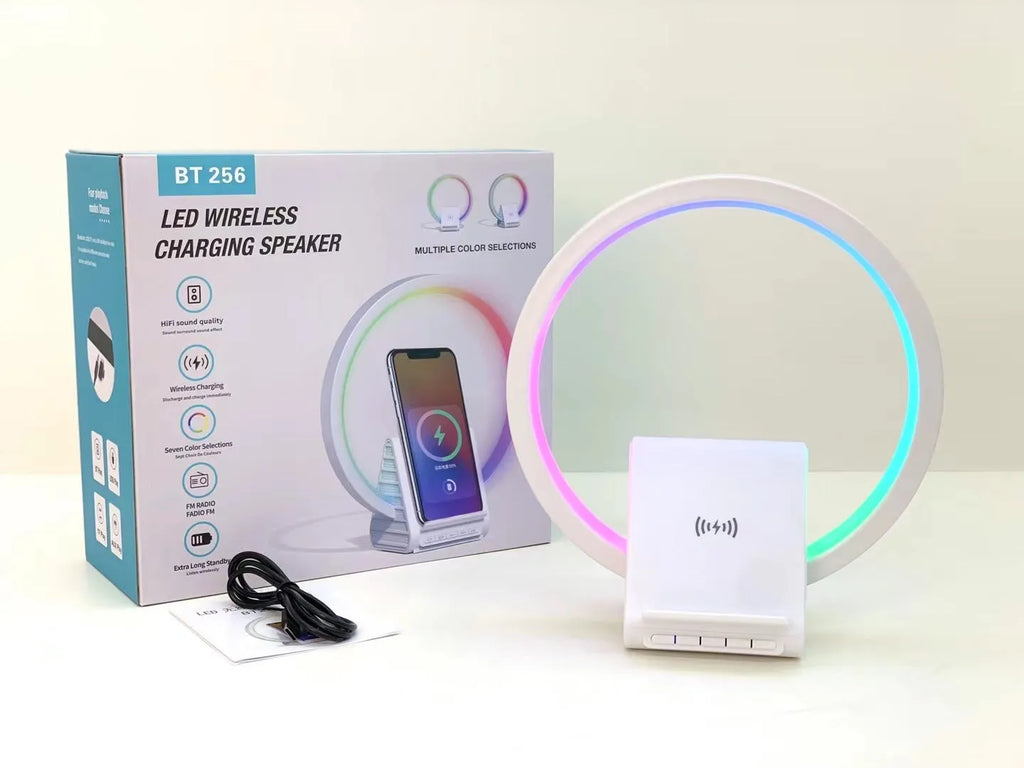 White rectangular smart device combining a wireless charging pad, Bluetooth speaker, and ambient light panel.