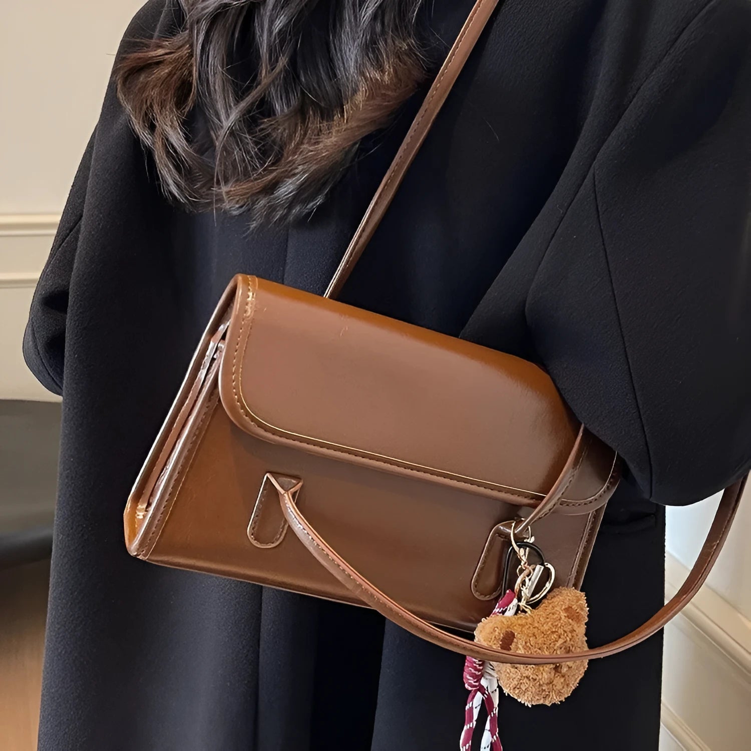 Brown women's PU leather crossbody shoulder bag with pendant, showing front view and adjustable double straps.